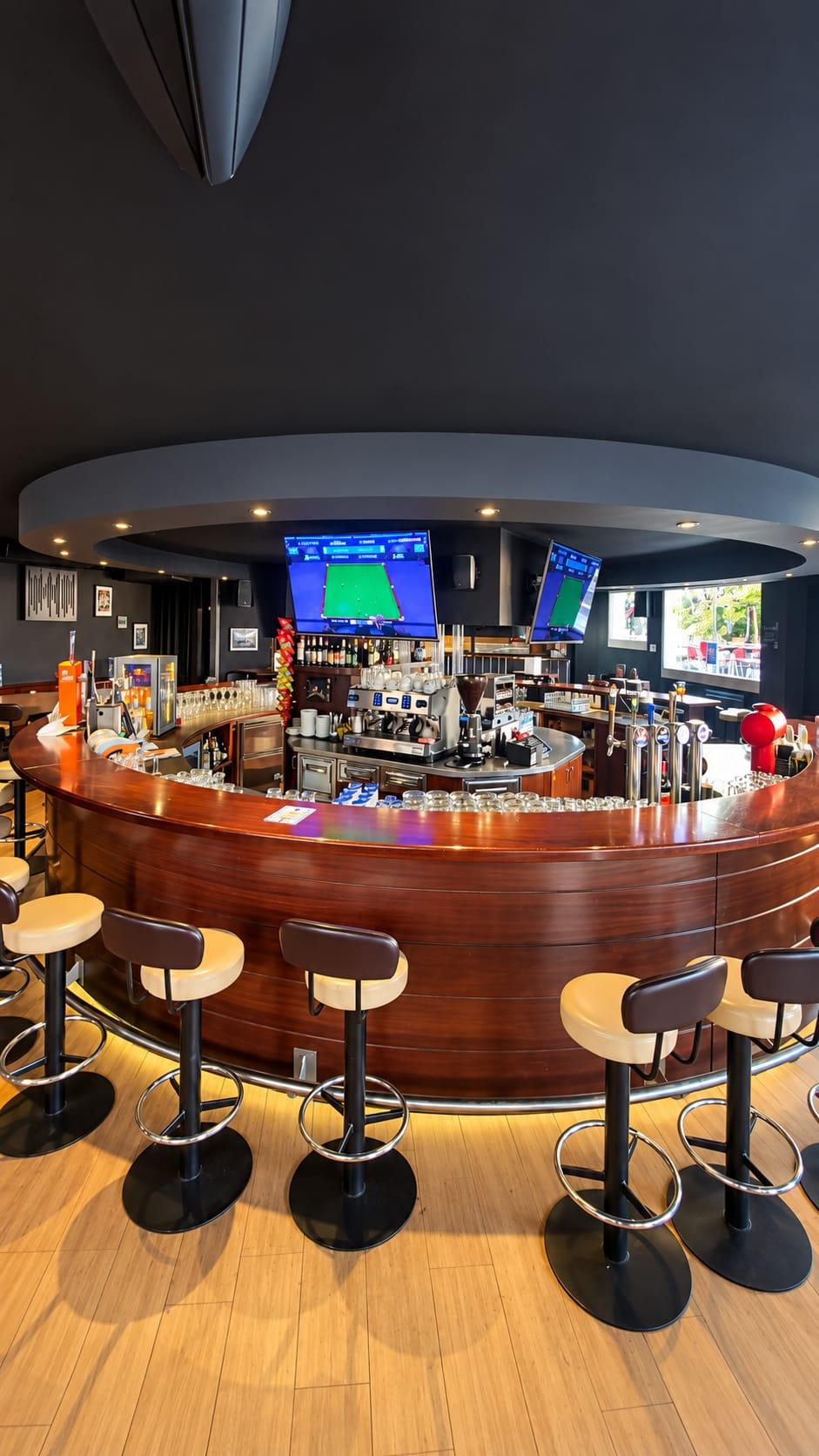 Le comptoir en bois de The Dugout Sports Bar et ses écrans de sport