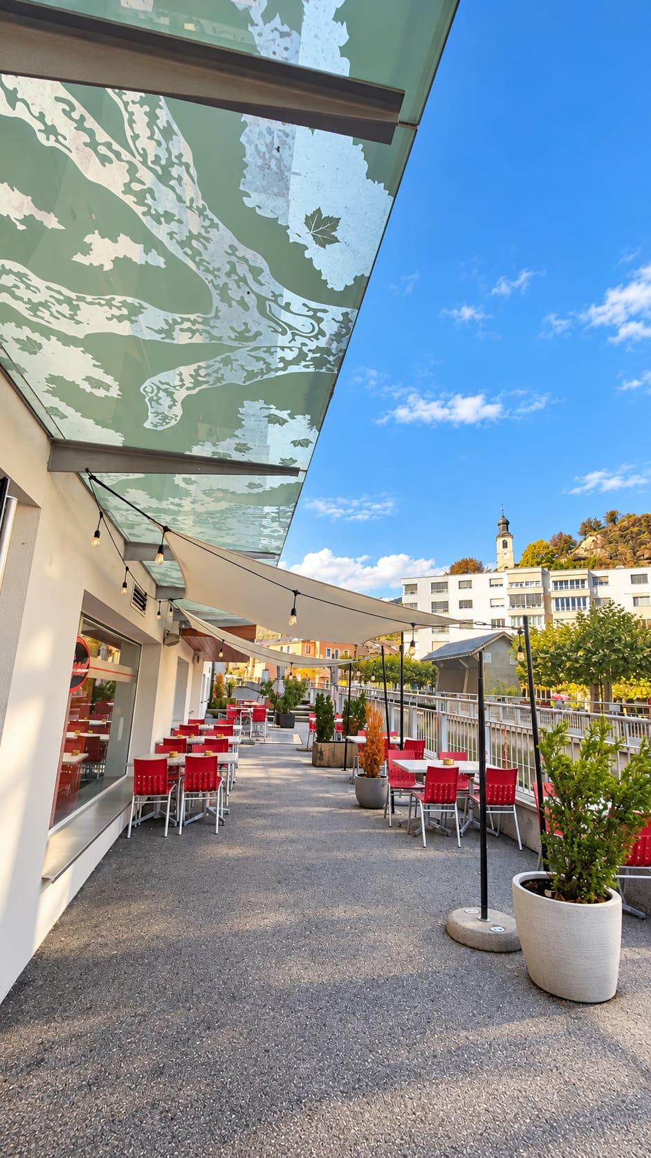 La terrasse de The Dugout Sports Bar, ses tables et ses chaises rouges